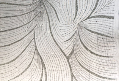Líneas curvas plateadas sobre un encaje gris-encaje hecho a mano